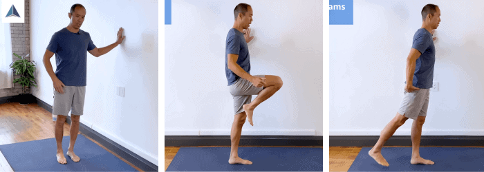 Standing person holding onto a wall, lifting one knee high to activate hip flexors, then bending the knee to activate hamstrings, followed by hip extension to engage glutes and quads.