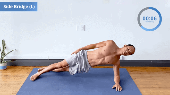 Person performing left side bridge on forearm with hips lifted, body aligned from head to heels.