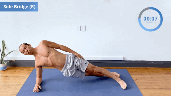 Right side bridge held on forearm with stacked feet and straight spine.